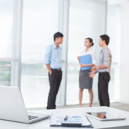 Close-up,Of,Workplace,In,Modern,Office,With,Business,People,Behind